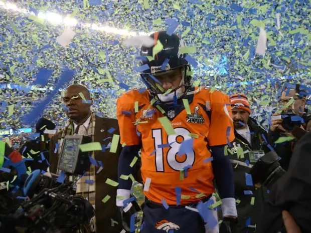 Quarterback walking off the field through confetti after a tough loss
